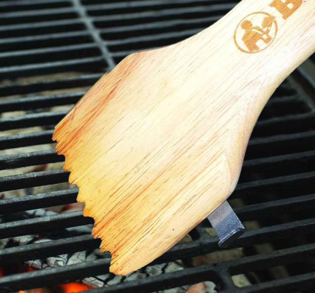 Wood grill scraper on grill grates.