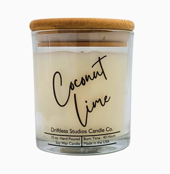 Coconut lime scented candle in a clear glass jar with bamboo lid, on a white background.