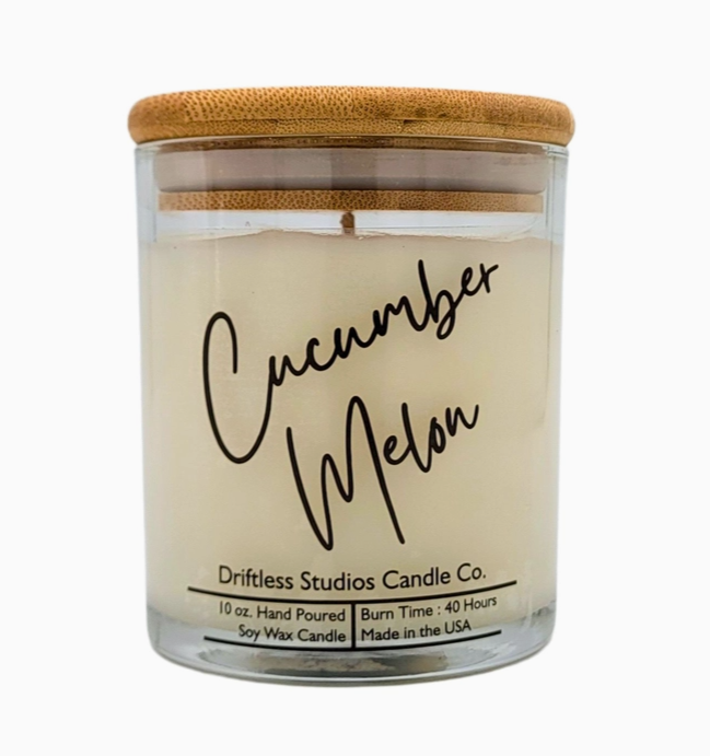 Cucumber melon scented candle in a clear glass jar with bamboo lid, on a white background.