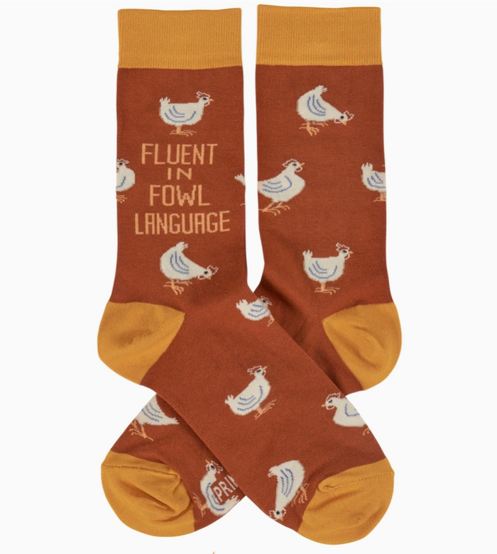 Pair of orange novelty socks featuring chicken designs and phrase    "fluent in fowl language," on a white background.