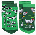 Two pairs of green baby socks featuring farm themes, on a white background.