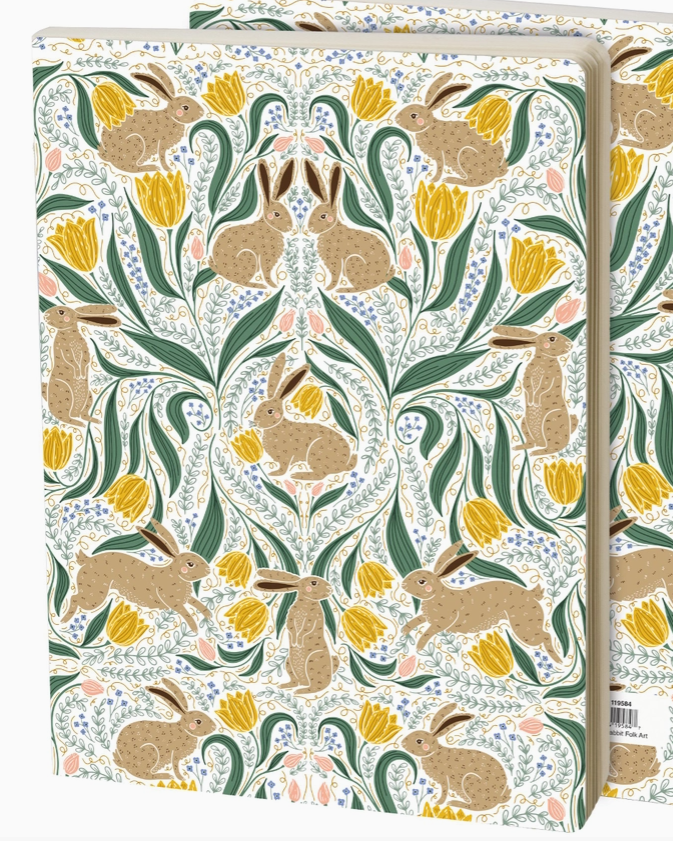 A notebook or journal featuring a William Morris-style floral and rabbit pattern on the cover, with two copies overlapping behind it on a white background.