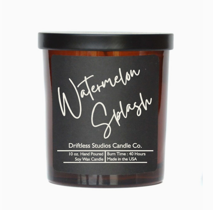Watermelon scented candle in an amber glass jar with black metal lid, on a white background.